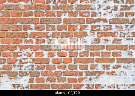 Old snowy wall made from red brick Stock Photo