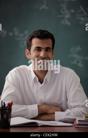 Young man sitting at his desk smiling Stock Photo