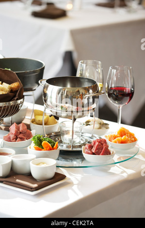 Fondue plate at a restaurant.  Cheese, traditional oil, and chocolate fondue Stock Photo