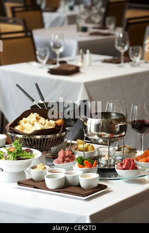 Fondue plate at a restaurant.  Cheese, traditional oil, and chocolate fondue Stock Photo