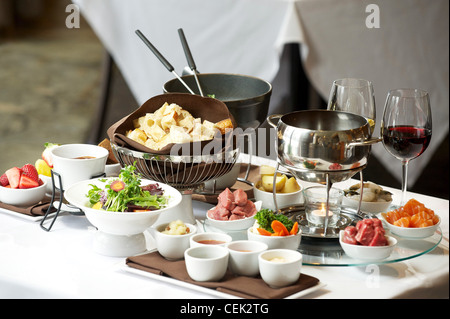 Fondue plate at a restaurant.  Cheese, traditional oil, and chocolate fondue Stock Photo