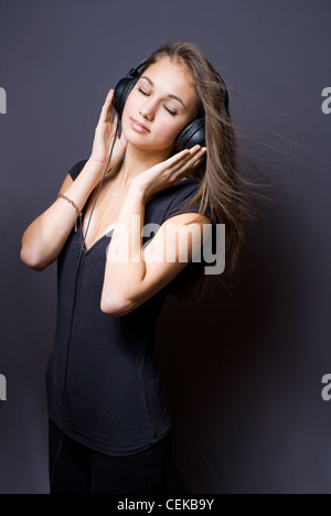 Artistic portrait of a beautiful young brunette girl immersed in music meditation Stock Photo