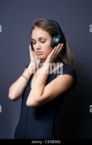 Portrait of a tranquil young brunette immersed in music. Stock Photo