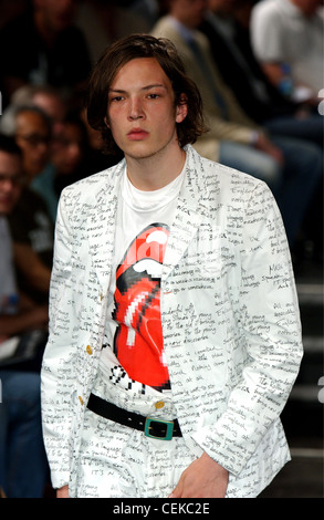 Commes Des Garcons Paris Menswear S S Male model wearing black and white suit writings all over, and white t shirt Rolling Stock Photo