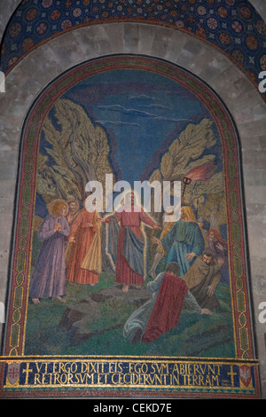 mosaic illustrates John 18:6 written in Latin under it: Jesus in Garden Gethsemane edge Kidron Valley disciples Judas appears Stock Photo
