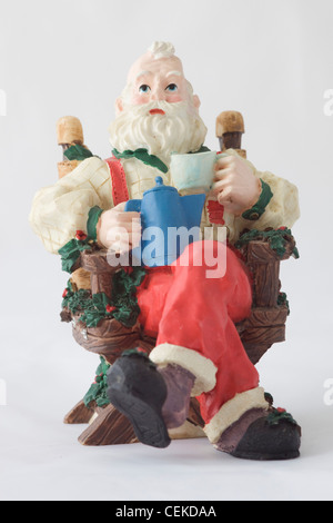 A Christmas Ornament Santa Claus Sitting on a chair Stock Photo