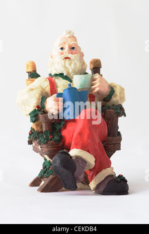 A Christmas Ornament Santa Claus Sitting on a chair Stock Photo