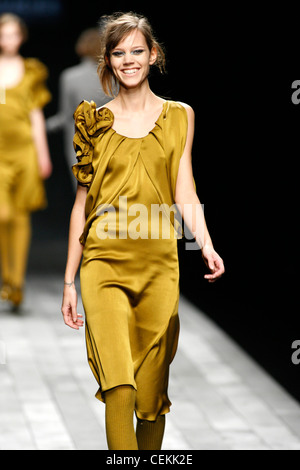 Vivienne Westwood Paris Ready to Wear Autumn Winter Model wearing gold  satin dress, flolength grey coat Stock Photo - Alamy
