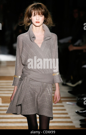 Sue Stemp New York Ready to Wear Autumn Winter  Bouffant hair, and grey wool wrap dress with gold bracelets Stock Photo