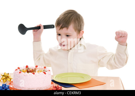 child with a large spoon is going to eat cake isolated on white background Stock Photo