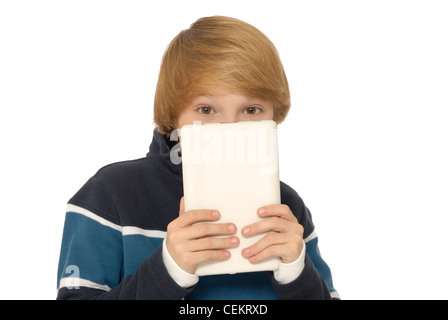 Eleven year old boy holding a tablet in front of his face and peeking up over the top of it, or hiding behind it. Stock Photo