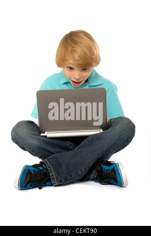 Eleven year old boy sitting and using laptop computer. Stock Photo