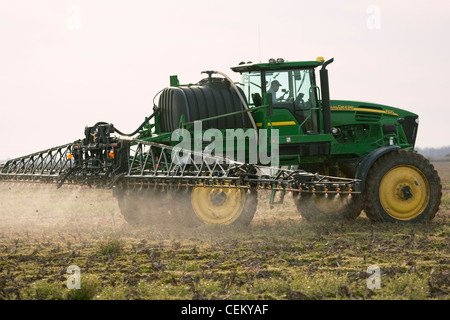 A John Deere sprayer applies pre-plant burndown herbicide in late Winter to a field that will be no-till planted to cotton. Stock Photo