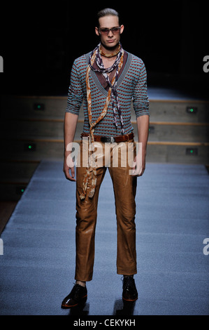 Byblos Milan Ready to Wear Spring Summer Model wearing narrow legged cropped brown leather trousers, brown leather belt, blue Stock Photo