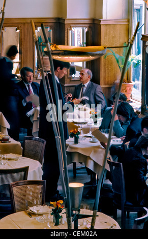France, Paris, Business Persons Having Lunch in Elegant, Contemporary Restaurant Maceo, Male Waiter Serving Tables in Dining Room Stock Photo
