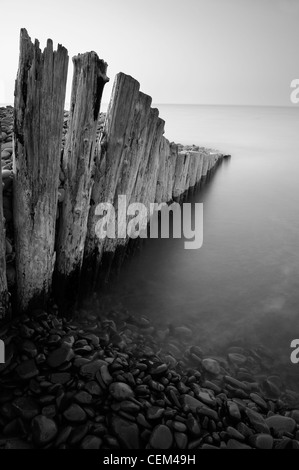 Wooden groynes and blurred water, Bossington beach, Somerset, UK Stock Photo