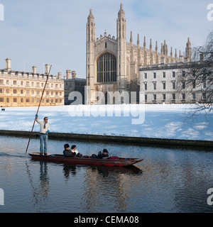 Punting along river Cam in winter snow with Kings College Chapel to the rear. Cambridge, England.