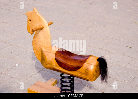 Swing wooden horse toy for kids carved out of wood. Spring and tail. Stock Photo