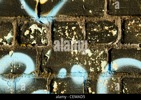 Background closeup of graffitti painted brick wall. Architectural dirty backdrop. Stock Photo