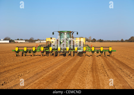 Agriculture - A John Deere tractor and 12-row planter plant grain corn in a conventionally tilled field / Arkansas, USA. Stock Photo