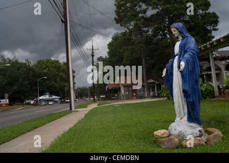 Statue of the Virgin Mary in a front yard in Lafayette, Louisiana with dark stormy clouds in the sky Stock Photo