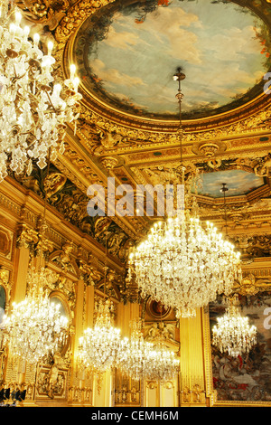 Opulent cristal chandeliers and gold leaves wood carved and painted ceiling, part of a french historical building, Lyon, France. Stock Photo