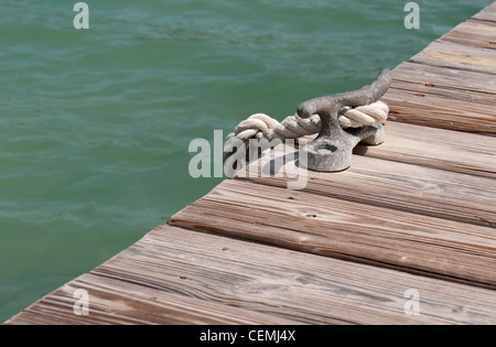 old iron mooring cleat on a wooden pier (green lagoon) Stock Photo