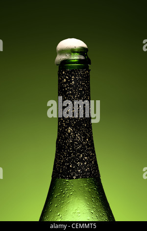 Cold wet bottle of champagne with Froth Stock Photo