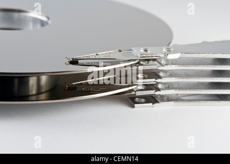 detail shot of a separated hard disk platter with actuator arm in light grey back Stock Photo