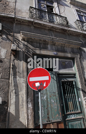 red and white no entry traffic sign, in front of run down old fashioned apartment block in Lisbon town centre, Portugal Stock Photo