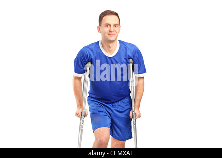 An injured soccer football player on crutches isolated against white background Stock Photo