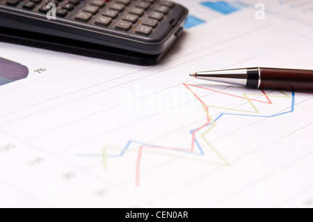 Graphs, calculator and paper statements for finance concept Stock Photo