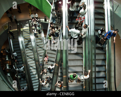 Shoppers ride the escalators in VivoCity shopping mall in Singapore. Stock Photo