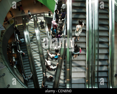 Shoppers ride the escalators in VivoCity shopping mall in Singapore. Stock Photo