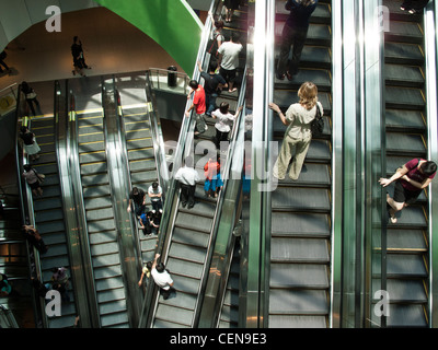 Shoppers ride the escalators in VivoCity shopping mall in Singapore. Stock Photo