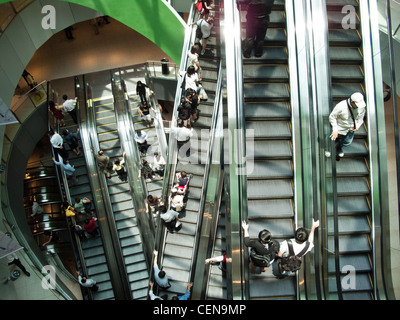 Shoppers ride the escalators in VivoCity shopping mall in Singapore. Stock Photo