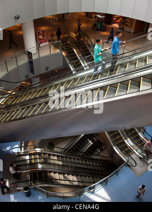 Shoppers ride the escalators in VivoCity shopping mall in Singapore. Stock Photo