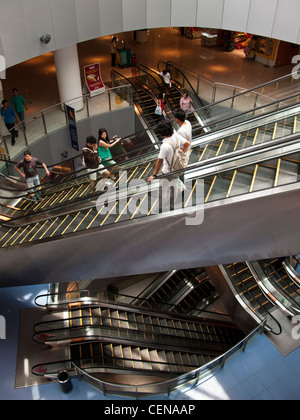 Shoppers ride the escalators in VivoCity shopping mall in Singapore. Stock Photo