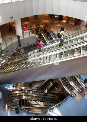 Shoppers ride the escalators in VivoCity shopping mall in Singapore. Stock Photo