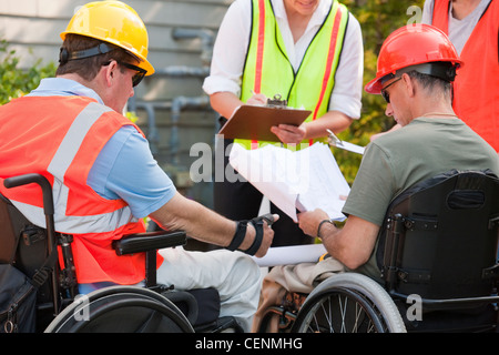 Project engineers discussing data at new building site Stock Photo