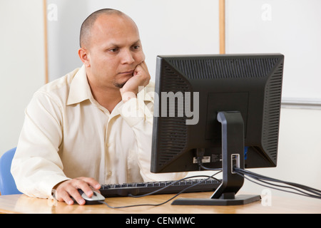 Hispanic engineering student studying computer display in a classroom Stock Photo