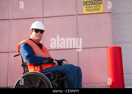 Facilities engineer in wheelchair at hard hat area Stock Photo