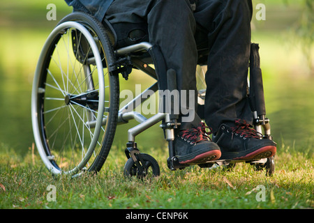 Low section view of a man in wheelchair with spinal cord injury in a park Stock Photo