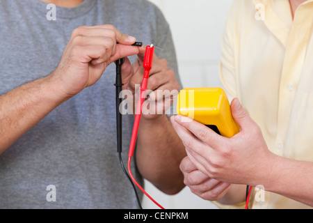Engineering students measuring resistor using multimeter Stock Photo
