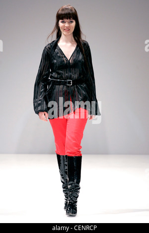 Aimee McWilliams London Ready to Wear Autumn Winter Model wearing red trousers, sheer black satin stripe loose collarless Stock Photo