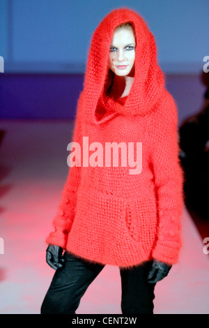 Aimee McWilliams London Ready to Wear Autumn Winter Model wearing large knit red jumper oversized hood and front pocket, black Stock Photo