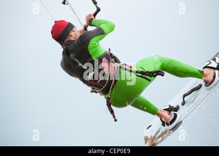 kite boarder kite surfer close up in powerful breeze flying and hanging in the sky aloft Stock Photo