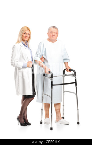 Full length portrait of a female doctor or nurse helping a senior patient to use a walker isolated on white background Stock Photo