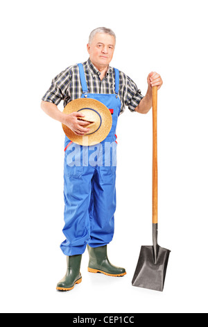 Full length portrait of a mature farmer with a shovel and a hand cart ...