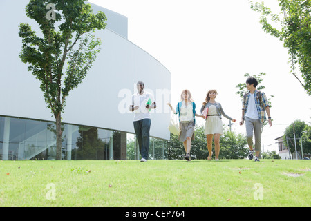 University students walking on lawn Stock Photo